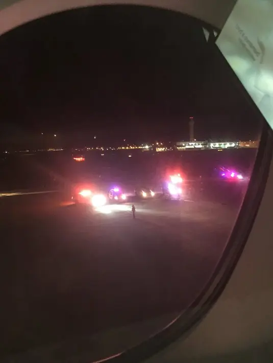 Gambar yang diambil seorang penumpang dari atas pesawat Air France 65 menunjukkan petugas memenuhi bandara Salt Lake City usai pesawat tersebut mendarat darurat setelah adanya ancaman bom, Utah, Selasa (17/11). (REUTERS/Keith Rosso)