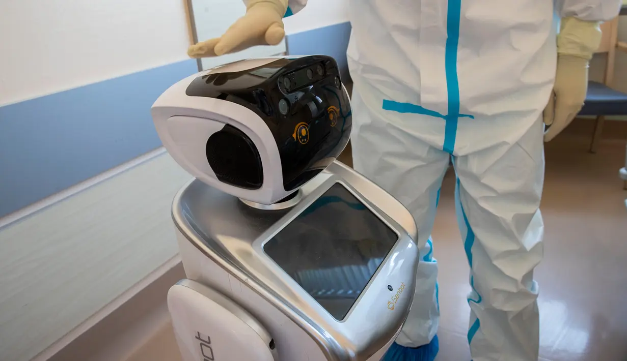 Wakil kepala unit perawatan intensif Flavio Tangian, menunjukkan sebuah robot di rumah sakit 'Ospedale di Circolo', di Varese, Italia, 8 April 2020. Sebanyak enam unit robot yang berjalan di atas roda ini membantu kinerja staf medis dalam merawat pasien virus corona Covid-19. (AP/Luca Bruno)