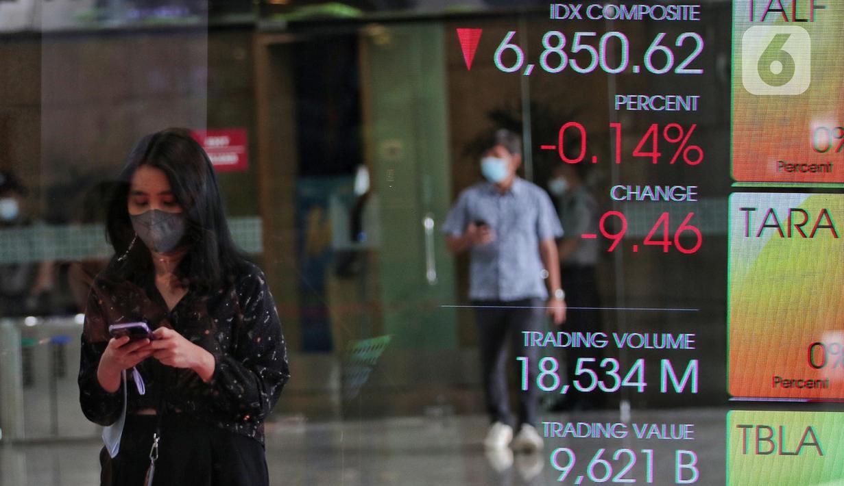 Karyawan melintasi layar yang menampilkan Indeks Harga Saham Gabungan (IHSG) saat acara Penutupan Perdagangan Bursa Efek Indonesia Tahun 2022 di Jakarta, Jumat (30/12/2022). PT Bursa Efek Indonesia (BEI) mencatat ada 59 perusahaan yang melakukan Initial Public Offering (IPO) atau pencatatan saham sepanjang 2022. Pada penutupan perdagangan akhir tahun, Indeks Harga Saham Gabungan (IHSG) ditutup lesu 0,14% atau 9,46 poin menjadi 6.850,62. (Liputan6.com/Angga Yuniar)
