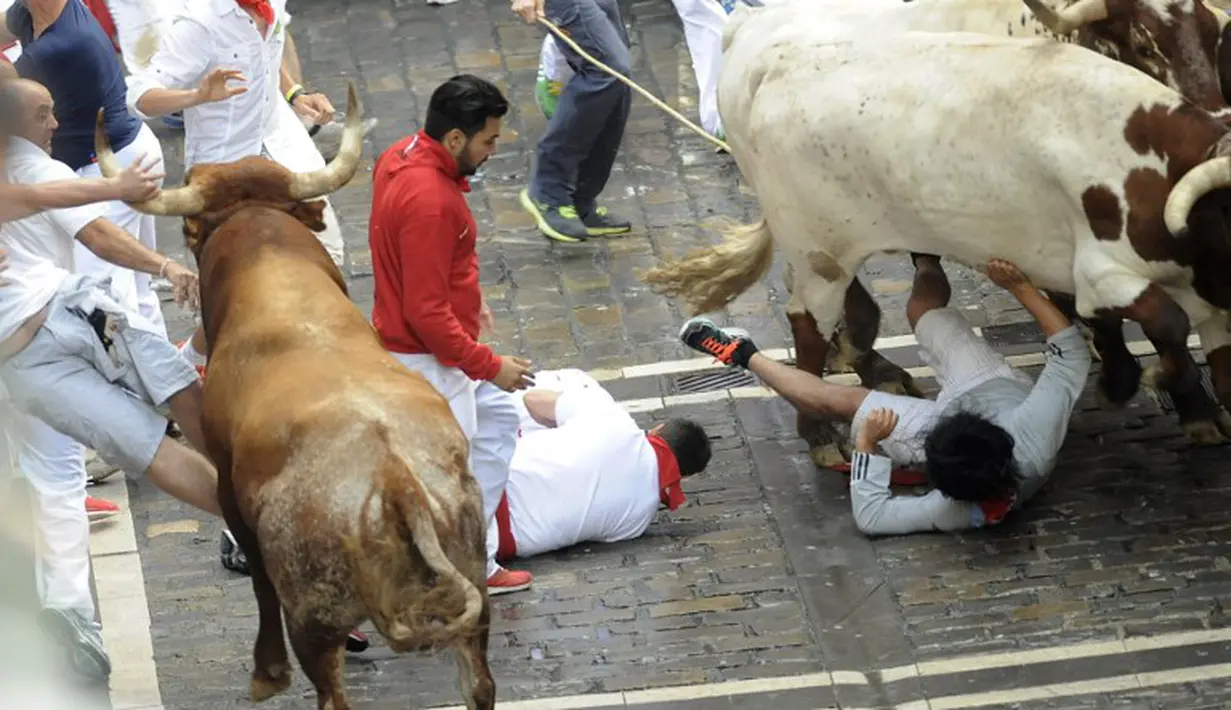 Peserta Run Bull dalam Festival San Fermin di Pamplona jatuh dan terinjak oleh banteng, Spanyol (10/07/2014) (AFP PHOTO/Ander GILLENEA)