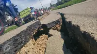 Kondisi jalan retak di Kabupaten Pidie Jaya, Aceh, Kamis (8/12). Gempa berkekuatan 6,5 SR pada Rabu pagi menyebabkan sejumlah ruas jalan retak dan mengalami kerusakan. (Liputan6.com/Angga Yuniar)