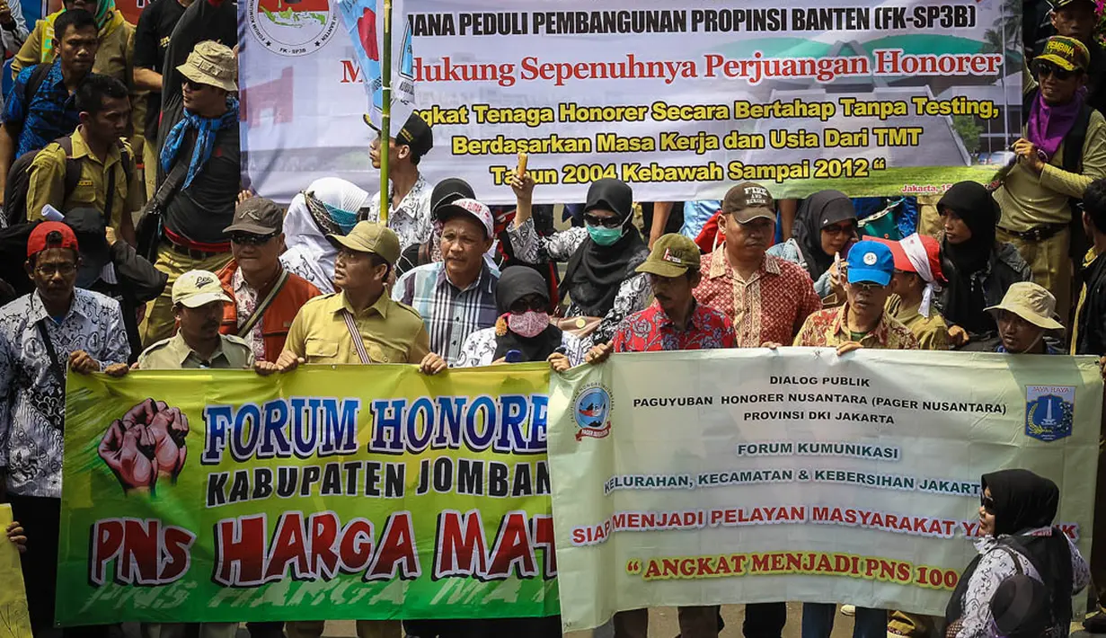 Ribuan pegawai honorer tersebut membawa berbagai spanduk bertuliskan tuntutan kenaikan status dari honorer menjadi PNS, Jakarta, (15/10/14). (Liputan6.com/Faizal Fanani) 