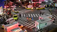 Seseorang, yang diyakini menderita serangan jantung, diangkut dengan tandu di distrik kehidupan malam populer Itaewon di Seoul, Korea Selatan, Minggu (30/10/2022). Lebih dari 140 ambulans dikerahkan ke tempat kejadian untuk membantu mengevakuasi para korban tragedi Halloween Itaewon. (Photo by JUNG YEON-JE / AFP)