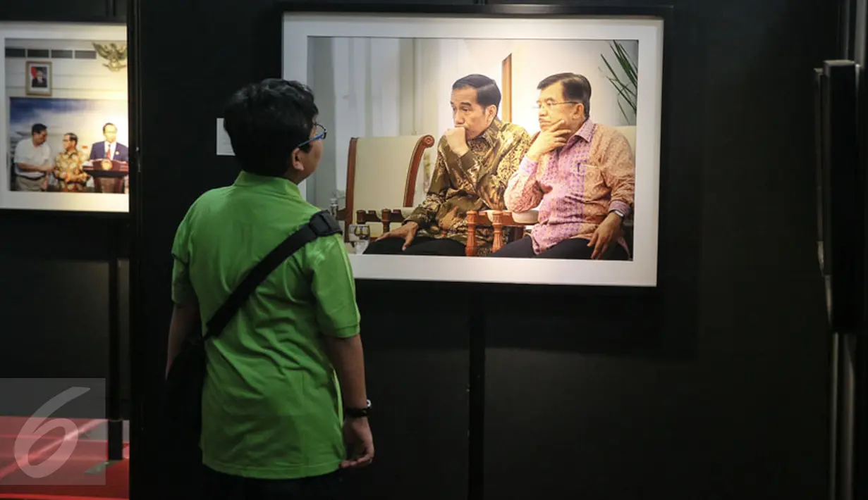 Pengunjung mengamati karya foto yang dipajang pada pameran foto jurnalistik Setahun Kerja Jokowi-JK di Museum Bank Mandiri, Jakarta, Jumat (18/12). Pameran itu mengangkat berbagai kegiatan Kabinet Kerja selama setahun. (Liputan6.com/Faizal Fanani)