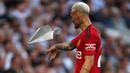 Pemain Manchester United, Antony memungut pesawat kertas yang dilemparkan penonton ke dalam lapangan pada laga pekan kedua Liga Inggris 2023/2024 melawan Tottenham Hotspur di Tottenham Hotspur Stadium, London, Inggris, Minggu (20/08/2023) WIB. (AFP/Adrian Dennis)