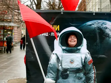 Seorang wanita tersenyum berpose di balik papan foto saat perayaan Cosmonautics Day di St Petersburg, Rusia pada Sabtu 12 April 2014.(REUTERS/Alexander Demianchuk)