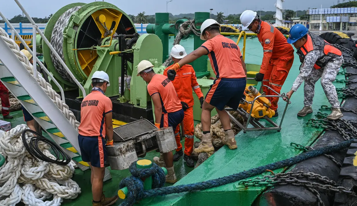 Personel penjaga pantai Filipina memuat peralatan skimmer yang akan digunakan dalam penanggulangan tumpahan minyak di sebuah pelabuhan di Limay, Bataan pada tanggal 26 Juli 2024. (Jam Sta Rosa/AFP)