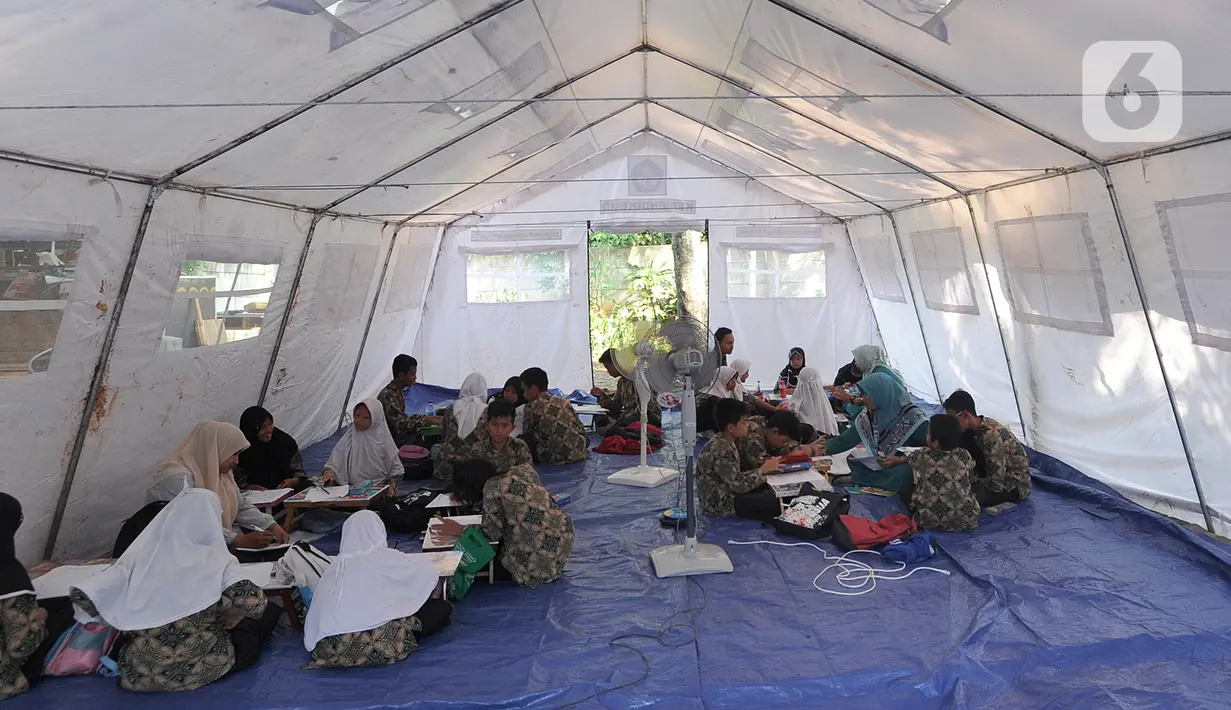 Suasana saat murid SMP dan SMA Sekolah Khusus (SKh) Assalam 01 melaksanakan ujian di tenda darurat halaman SKh Assalam 02, Ciater, Serpong, Tangerang Selatan, Selasa (3/12/2019). Ujian diikuti murid penyandang tunarungu, tunawicara, dan tunagrahita tingkat SD hingga SMA. (merdeka.com/Arie Basuki)