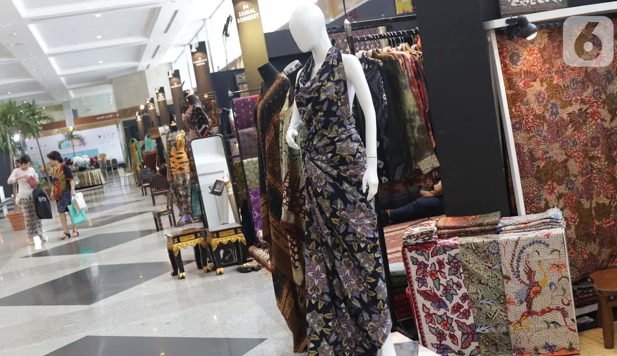 Pengunjung berjalan di antara koleksi batik yang dipamerkan pada Interior and Craft (ICRA) Exhibition 2019 di Hall A Jakarta Convention Center (JCC), Senayan, Jakarta, Minggu (6/10/2019). Ratusan motif batik dari berbagai daerah dipamerkan pada ajang ini. (Liputan6.com/Helmi Fithriansyah)