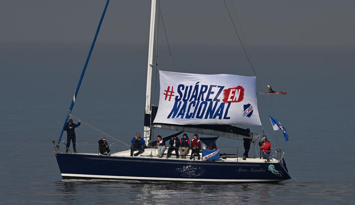 Sebuah kapal yang dihias tulisan 'Suarez en Nacional" berlayar saat sang pemain menghadiri upacara penyambutan sebagai pemain baru Nacional di Stadion Gran Parque Central, di Montevideo, pada 31 Juli, 2022. Luis Suarez kembali ke Uruguay untuk bergabung dengan Nacional, klub tempat ia memulai karirnya 17 tahun lalu sebagai salah satu striker terbaik di generasinya. (AFP/Pablo Porciuncula)