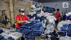 Relawan merapikan karung yang berisi pakaian bekas tidak layak pakai di Jakarta, Kamis (17/4/2025). (Liputan6.com/Angga Yuniar)