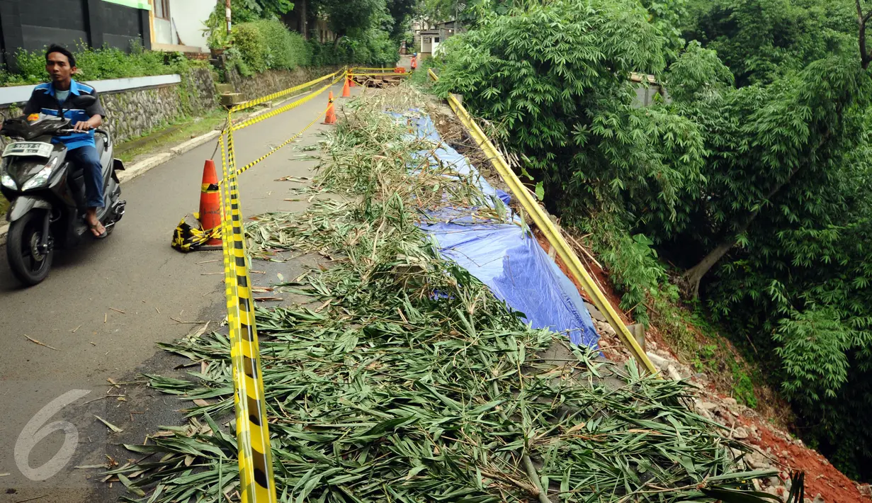 Warga melintas di jalan Gardu, Jagakarsa yang mengalami longsor pada Jumat (12/2) lalu, Jakarta, Sabtu (13/2/2016). Longsor terjadi akibat guyuran hujan deras dan tidak ada korban dalam peristiwa ini. (Liputan6.com/Helmi Fithriansyah)