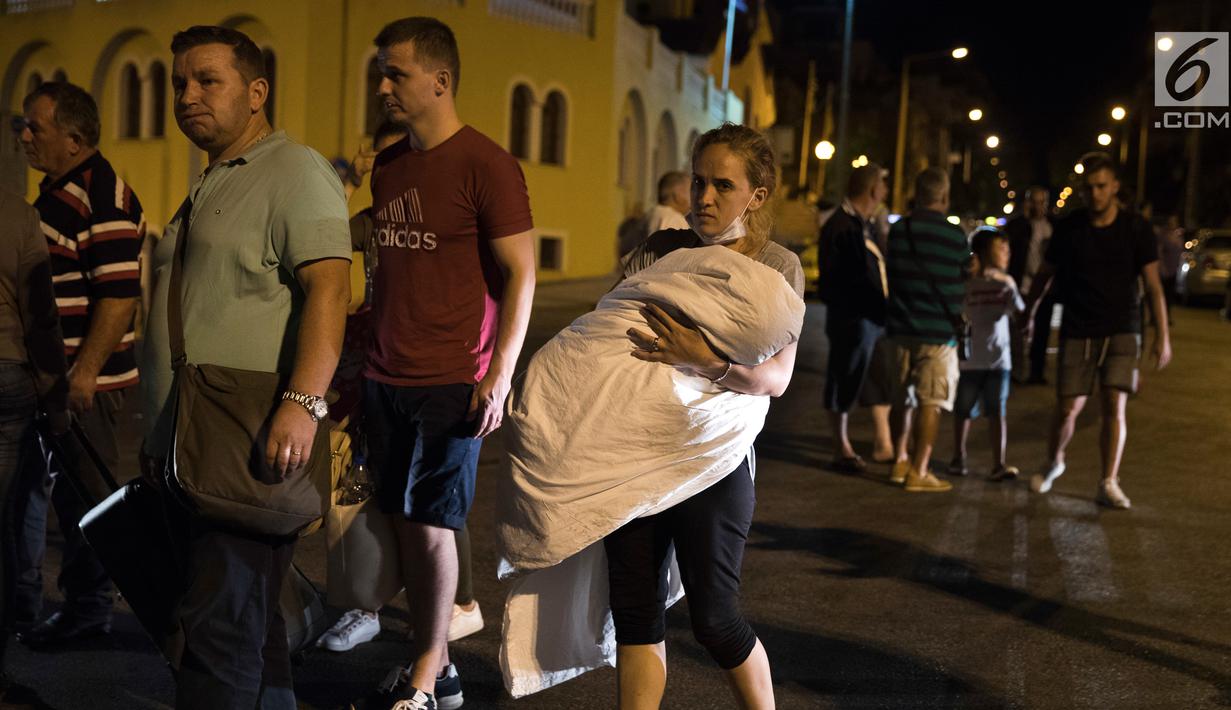 Sejumlah penumpang kapal feri Eleftherios Venizelos dievakuasi petugas saat kapal terbakar di pelabuhan Piraeus, dekat Athena, (29/8). Kapal feri tersebut mengangkut 875 penumpang dan 141 awak. (AP Photo/Petros Giannakouris)