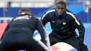 Bek Prancis, Ferland Mendy, melakukan pemanasan saat mengikuti sesi latihan di Stade De France, Paris, Minggu (19/11/2018). Prancis akan mejalani laga persahabatan melawan Uruguay. (AFP/Franck Fife)