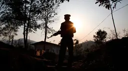 Seorang Tentara Kemerdekaan Kachin berjaga di Lawa Yang, di luar Laiza, negara bagian Kachin, Myanmar, 20 Maret 2018. Konflik Kachin menjadi salah satu konflik terlama di bumi. (AP Photo/Esther Htusan)