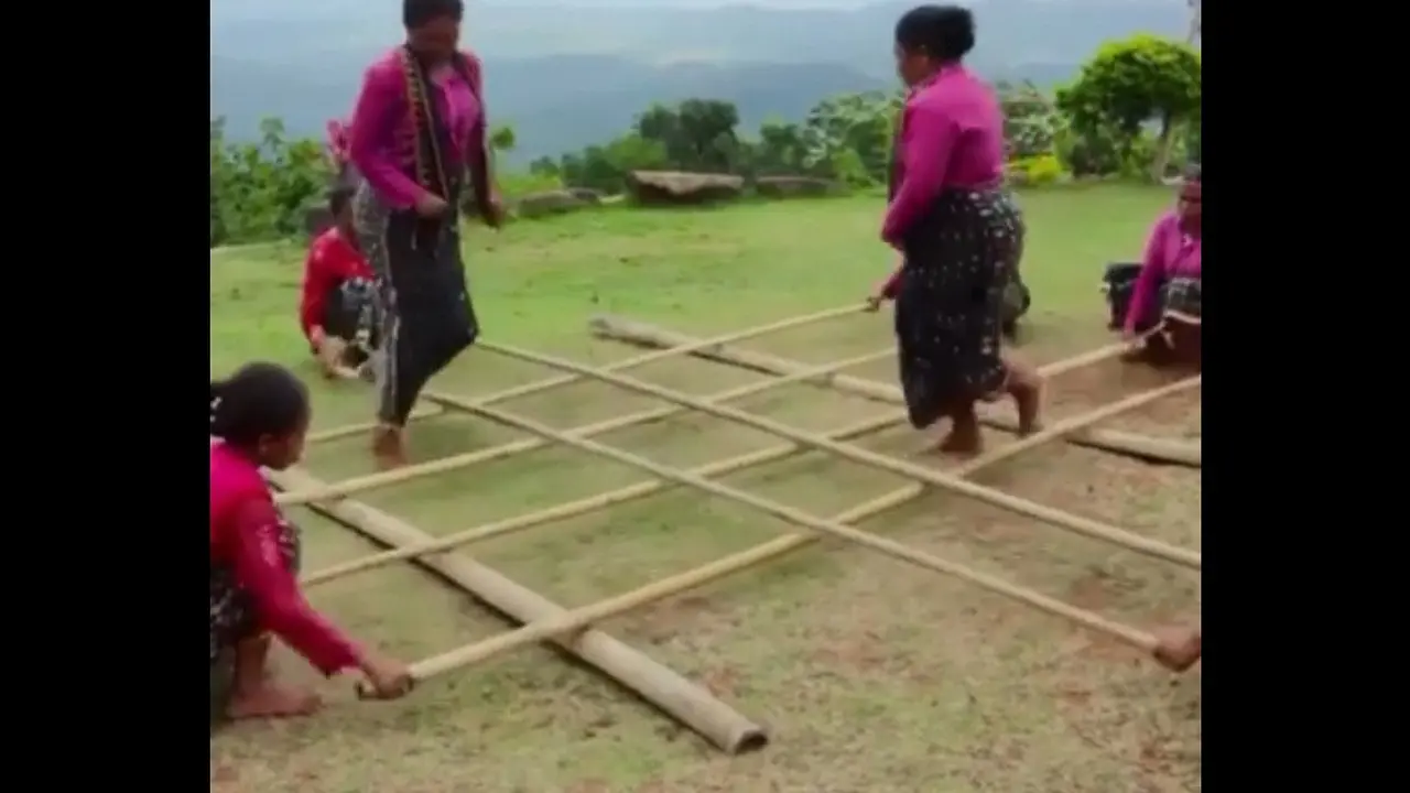 Wanita Manggarai Flores berbaju merah muda sedang main permainan Rangku Alu