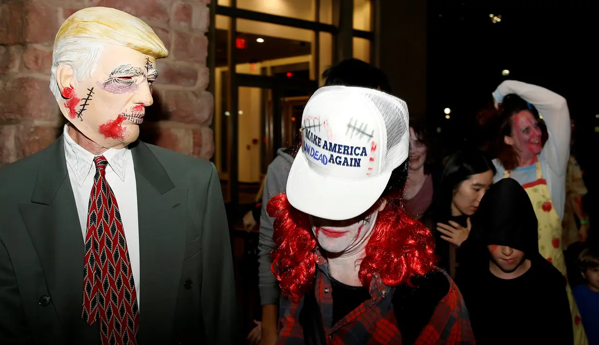 Seorang warga mengenakan topeng sosok Zombie Donald Trump ramaikan perayaan Halloween di Silver Spring, Maryland, AS (29/10). Menjelang pemilihan Presiden AS, Donald Trump banyak dijadikan obyek topeng dalam perayaan Halloween. (Reuters/Gary Cameron)