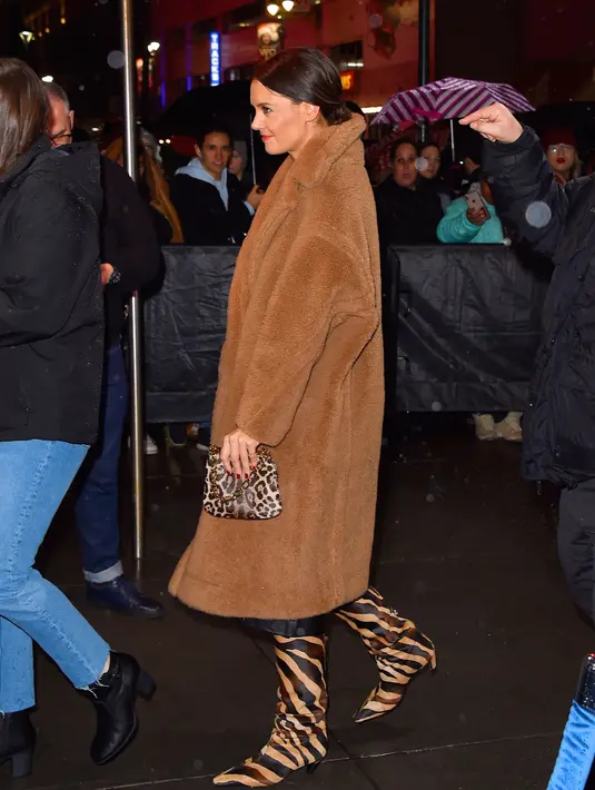 Katie Holmes tidak pernah takut mengenakan motif yang bertabrakan. Seperti saat ia tampil percaya diri dengan sepatu boot, mantel dan tas bermotif macan tutul dari Max Mara. Foto: Vogue.