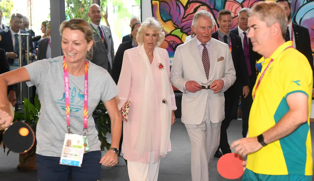 Pangeran Charles bersama istrinya Camilla Parker menonton atlet bermain tenis meja selama kunjungan ke desa atlet Goldwe Common Games 2018 di Gold Coast (5/4). (AFP Photo/Pool/William West)