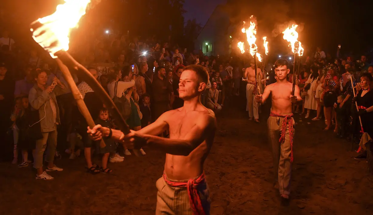 Pria Belarusia membawa obor dekat Sungai Berezina pada Hari Ivan Kupala di Desa Parichi, sekitar 200 km (125 mil) selatan Parichi, Belarusia, Juli 6, 2022. Ivan Kupala atau Hari St. John atau Hari Pertengahan Musim Panas adalah karnaval tradisional yang berpusat di sekitar api unggun dengan banyak makanan dan tarian. (AP Photo/Viktor Drachev)