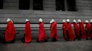 Aktivis yang mendukung dekriminalisasi aborsi berjalan di luar Kongres, Buenos Aires, Argentina, Rabu (25/7). Para aktivis mengenakan jubah merah dan topi putih seperti tokoh dalam serial televisi 'The Handmaid's Tale'. (AP Photo/Natacha Pisarenko)