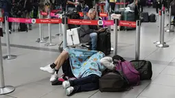 Seorang penumpang maskapai Viva Air tidur di bandara setelah maskapai berbiaya rendah itu menangguhkan operasinya di Bandara Internasional El Dorado di Bogota, Kolombia, Selasa (28/2/2023). Sejumlah penumpang bermalam di bandara, banyak yang tidur di lantai sambil menunggu penerbangan ke tujuan yang dituju. (AP Photo/Fernando Vergara)