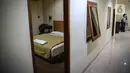 Pekerja merapikan tempat tidur kamar hotel yang berada di area SMK Negeri 27 Jakarta, Selasa (21/4/2020). Pemprov DKI Jakarta menyiapkan sejumlah sekolah sebagai tempat tinggal tenaga medis dan ruang isolasi pasien virus corona COVID-19. (Liputan6.com/Faizal Fanani)