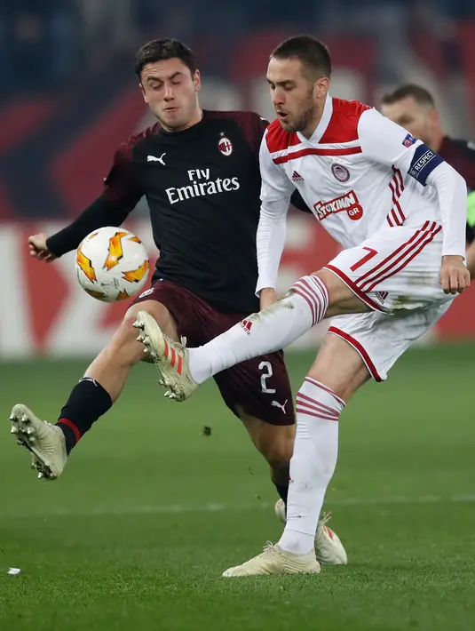 Pemain Olympiakos Piraeus, Kostas Fortounis berebut bola dengan pemain AC Milan,  Davide Calabria dalam laga keenam Grup F Liga Europa di Stadion Georgios Karaiskakis, Kamis (13/12). AC Milan takluk 1-3 dari Olympiacos. (AP /Thanassis Stavrakis)
