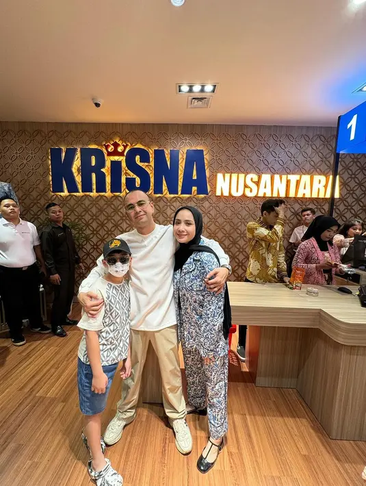 Melihat gaya Nagita Slavina memadukan setelan atasan dan bawahan yang berwarna dasar biru navy dengan corak semarak, mengenakan hijab hitam polos. [Foto: Instagram/raffinagita1717]