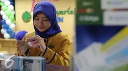 Petugas Bank menghitung uang pecahan Rp100.000 di Bank Bukopin Syariah, Jakarta, Selasa (29/12). Namun kurs tengah Bank Indonesia mencatat rupiah menguat tipis 0,003% ke Rp 13.639 per dollar AS. (Liputan6.com/Angga Yuniar)