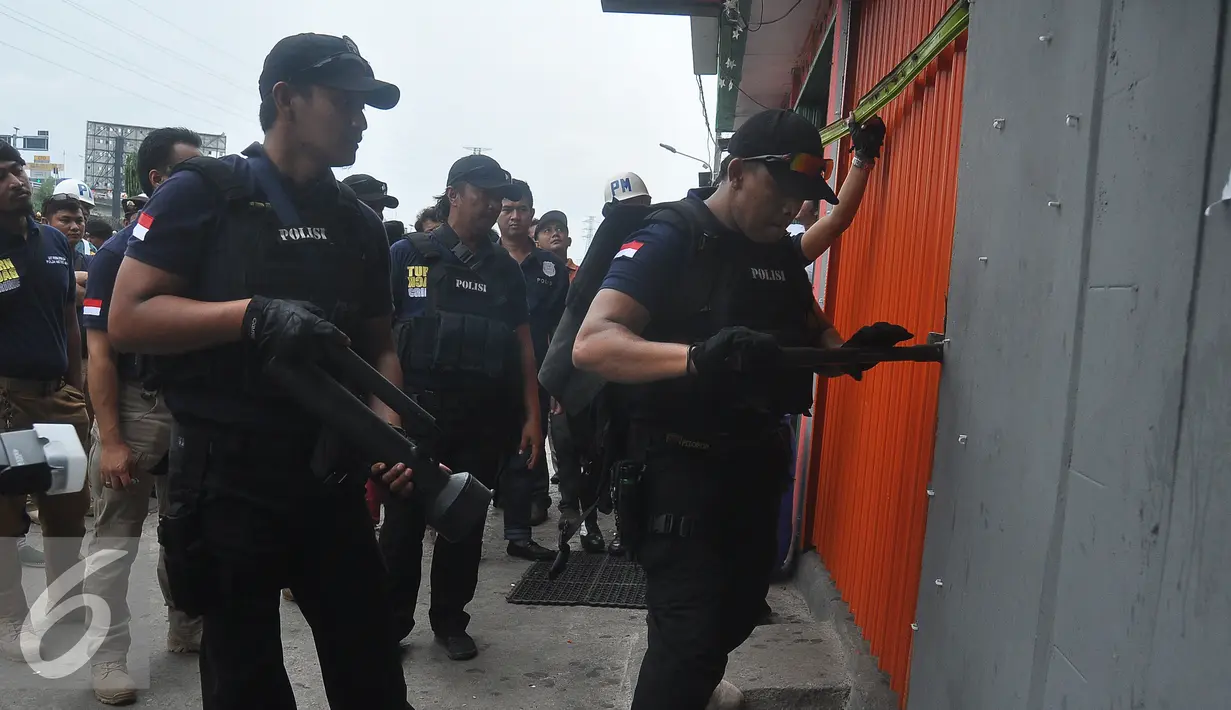 Petugas polisi membuka salah satu kafe dalam operasi Pekat di Kalijodo, Jakarta Utara, Sabtu (20/2). Operasi ini untuk menangani penyakit masyarakat di kawasan yang terkenal dengan prostitusi dan perjudian tersebut. (Liputan6.com/Faizal Fanani)