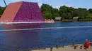 Seorang wanita melihat 'The Mastaba', sebuah karya luar ruangan yang terdiri dari lebih dari 7.000 tumpukan tong oleh seniman Bulgaria Christo Vladimirov Javachef di danau Serpentine di Hyde Park di London (11/6). (AFP Photo/Niklas Hallen)