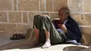 Seorang pria membaca ayat-ayat Alquran saat menunggu waktu berbuka puasa selama bulan suci Ramadhan di Masjid Al-Omari, Kota Gaza, Palestina, 13 April 2022. (AP Photo/Adel Hana)