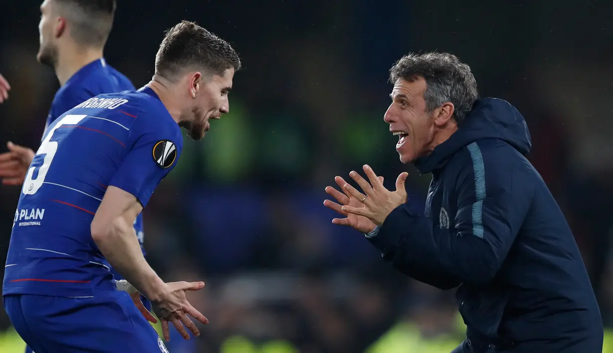 Gelandang Chelsea, Jorginho dan asisten pelatih Zola berselebrasi setelah pertandingan melawan Eintracht Frankfurt pada semifinal Liga Europa di stadion Stamford Bridge, London (10/5/2019). Chelsea menang adu penalti atas Eintracht Frankfurt setelah laga berakhir imbang 1-1. (AP Photo/Alastair Grant