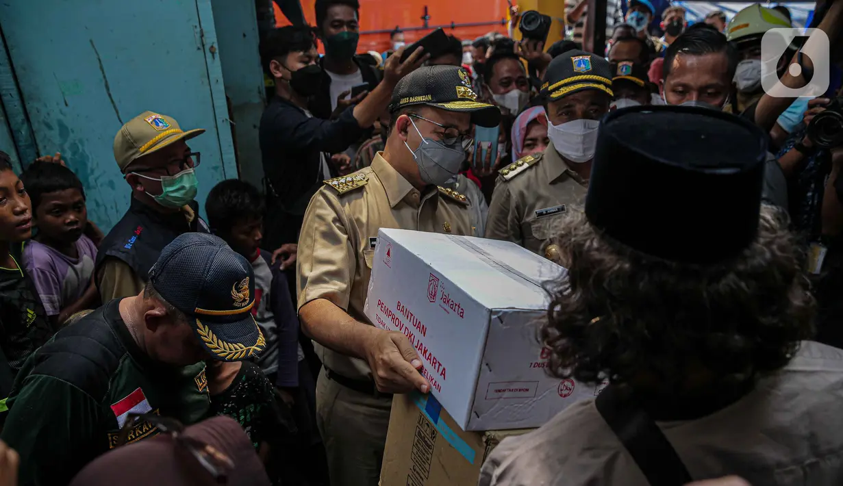 <p>Gubernur DKI Jakarta Anies Baswedan memberi bantuan saat meninjau lokasi kebakaran di Pasar Gembrong, Jakarta, Senin (25/4/2022). Anies datang didampingi sejumlah pejabat kemudian langsung berkeliling lokasi kebakaran dan berbincang dengan warga. Beberapa warga menceritakan kejadian tersebut kepada Anies. (Liputan6.com/Faizal Fanani)</p>