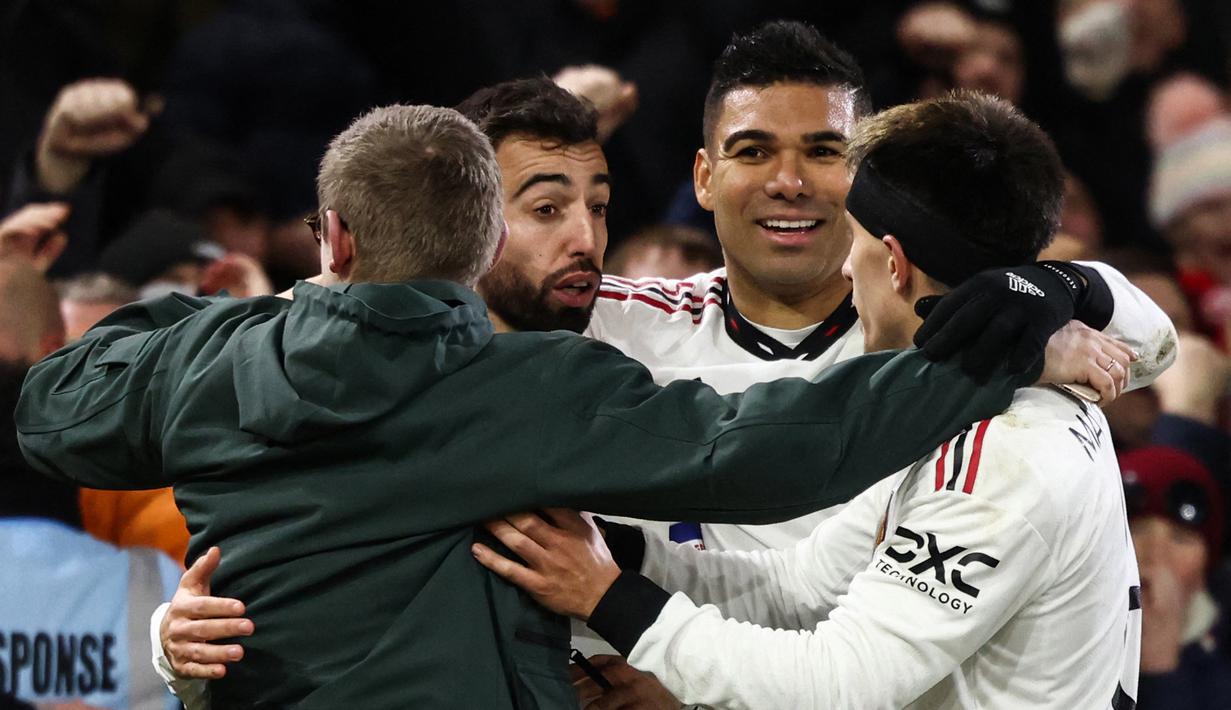 Ada kejadian menarik setelah gol ketiga MU yang dicetak oleh Bruno Fernandes. Seorang suporter lolos dari kawalan petugas dan melakukan selebrasi bersama Bruno Fernandes, Casemiro, dan Lisandro Martinez. (AFP/Darren Staples)
