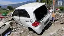Sebuah mobil Honda Brio menjadi incaran jarahan korban gempa dan tsunami di Palu Grand Mal, Palu, Jumat (5/10). Warga korban gempa bumi mengambil ban dan interior mobil. (Liputan6.com/Fery Pradolo)