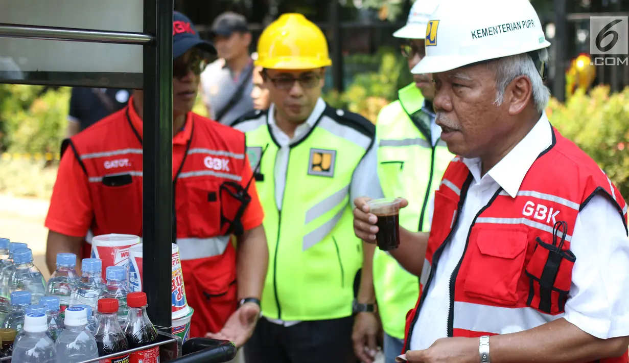 Menteri PUPR, Basuki Hadimuljono menikmati kopi yang dijajakan pedagang seusai meninjau renovasi stadion di Gelora Bung Karno (GBK), Jakarta, Kamis (10/5). Basuki meninjau kesiapan fasilitas dan prasarana untuk Asian Games 2018 (Liputan6.com/Angga Yuniar)