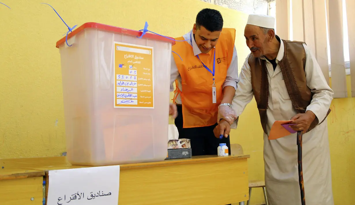 Usai menentukan pilihan, jari para pemilih dalam Pemilu Parlemen di Libya diberikan tanda tinta oleh petugas TPS setempat, Al Bayda, (25/6/2014). (REUTERS)
