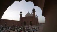 Orang-orang berbuka puasa selama bulan suci Ramadhan di masjid bersejarah Badshahi, di Lahore, Pakistan (3/4/2022). Ramadhan ditandai dengan puasa setiap hari dari fajar hingga matahari terbenam. (AP Photo/K.M. Chaudary)