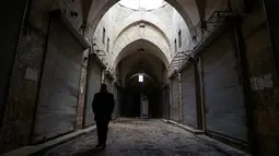 Seorang pria berjalan di lorong di pasar lama di kota tua Aleppo, Suriah (21/1). Kota tua ini meliputi area sekitar 3,5 kilometer persegi dengan lebih dari 120.000 penduduk. (AP Photo / Mstyslav Chernov)