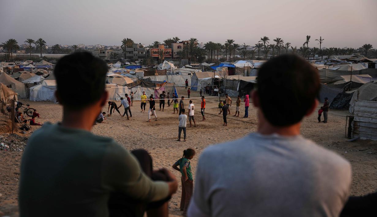 Anak-anak muda Palestina bermain voli di kamp tenda pengungsian di Zawayda, Jalur Gaza tengah, Selasa 4 November 2025. Berolahraga menjadi salah satu cara bagi anak muda Palestina untuk menunjukkan ketahanan dan mencari secercah kegembiraan di tengah konflik yang berkepanjangan antara Israel dan Hamas di Gaza. (AP Photo/Abdel Kareem Hana)