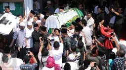 Sejumlah pelayat menggotong jenazah Ketua KPU Husni Kamil Manik usai disalatkan di Kompleks KPU, Jakarta, Jumat (8/7). Husni Kamil Manik wafat diusia 40 tahun pada Kamis malam (7/7). (Liputan6.com/Helmi Fithriansyah)