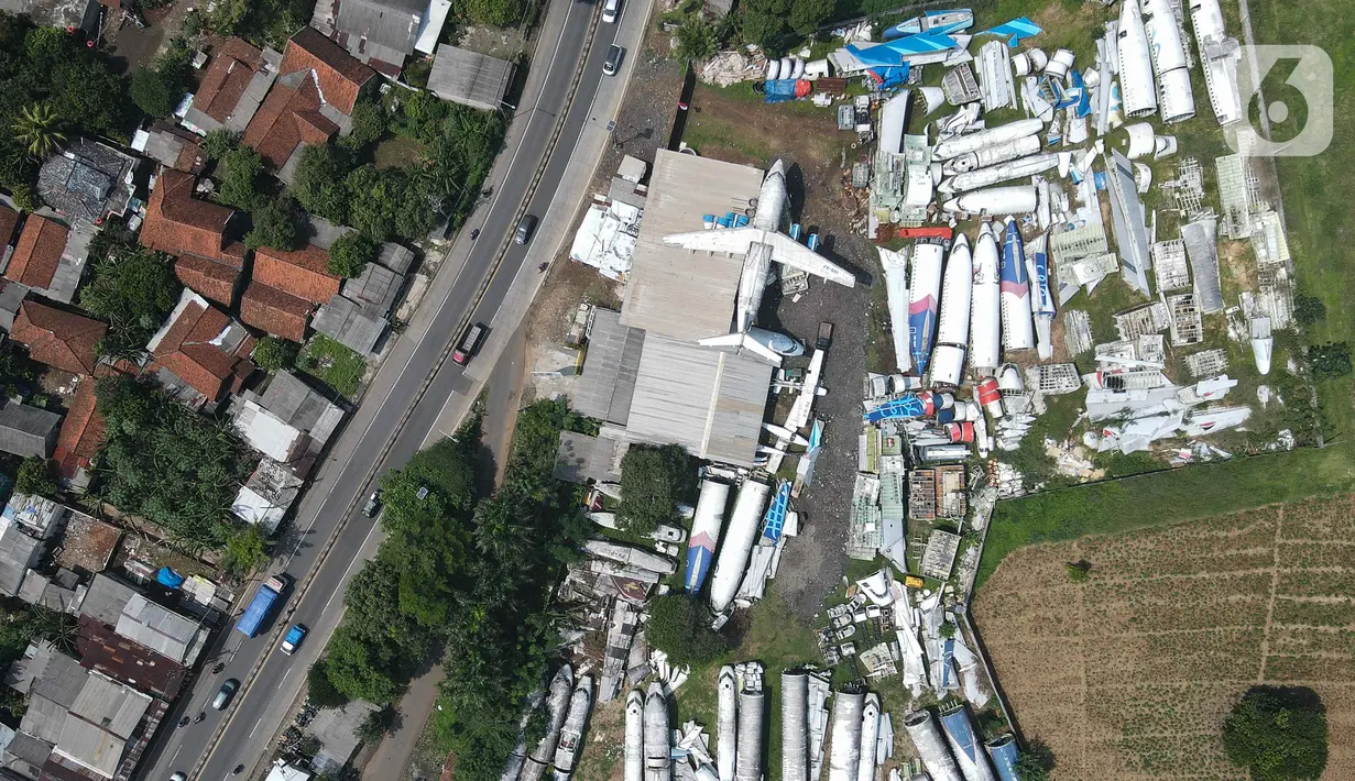 Foto udara bangkai pesawat di sebuah lahan kawasan Jampang, Kabupaten Bogor, Jawa Barat, Kamis (25/8/2022). Keberadaan belasan bangkai pesawat dari berbagai jenis maskapai terongok di area lahan kosong tersebut sudah ada sejak 2019 silam. (Liputan6.com/Herman Zakharia)