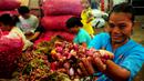 Seorang pedagang menunjukkan bawang merah di Pasar Induk sayur dan buah, Kramat Jati, Jakarta, Jumat, (13/3/2015). Harga bawang merah di sejumlah pasar menembus Rp 30 ribu per kg atau mengalami kenaikan sekitar Rp 2000-5000/kg. (Liputan6.com/Yoppy Renato)