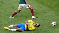 Penyerang timnas Brasil, Neymar mengerang kesakitan di atas lapangan pada babak 16 besar Piala Dunia 2018 melawan Meksiko di Samara Arena, Senin (2/7). Neymar memang menjadi bintang saat Brasil mengalahkan Meksiko 2-0. (AP/Sergei Grits)