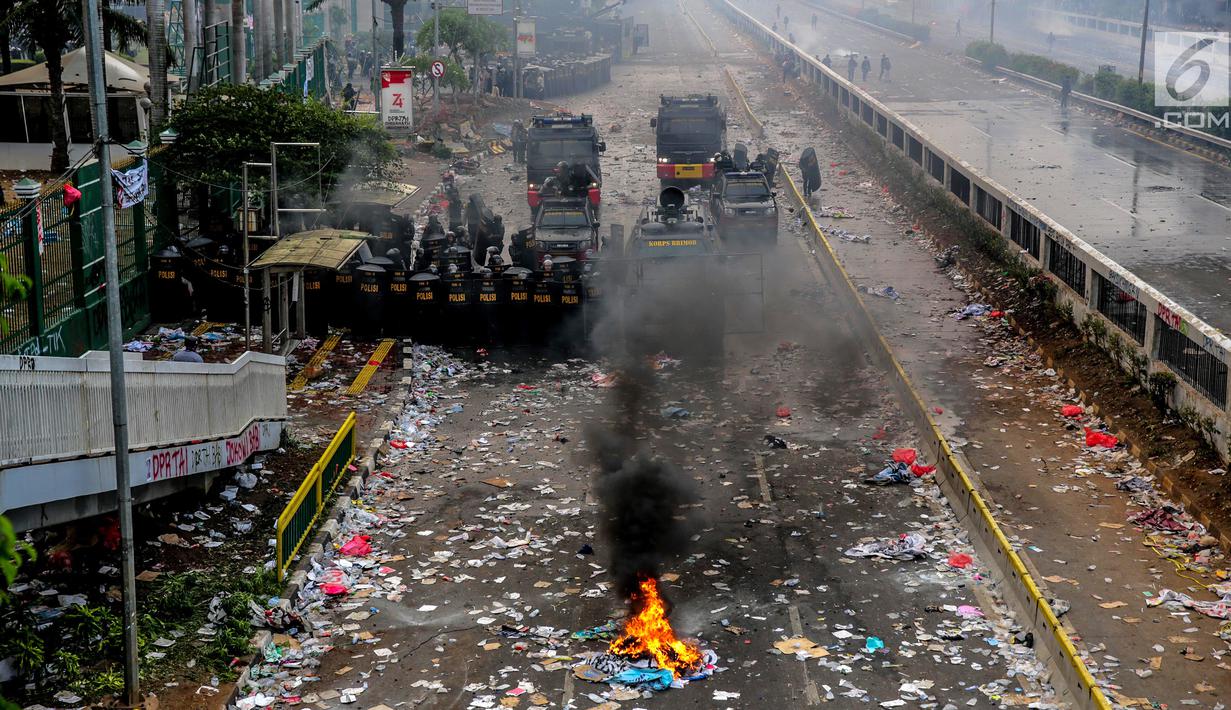Polisi membuat barikade saat menghalau mahasiswa dalam demonstrasi menolak pengesahan RUU KUHP dan revisi UU KPK di depan Gedung DPR, Jakarta, Selasa (24/9/2019). Dua polisi dan tiga mahasiswa dilaporkan terluka dalam demonstrasi tersebut. (Liputan6.com/Faizal Fanani)
