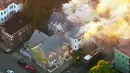 Petugas pemadam kebakaran berusaha menjinakkan api yang melalap rumah di Lawrance, dekat Boston, AS, Kamis (13/9). Rentetan ledakan dan kebakaran di tiga komunitas utara Boston itu membuat pihak berwenang memutus aliran listrik dan gas. (WCVB via AP)