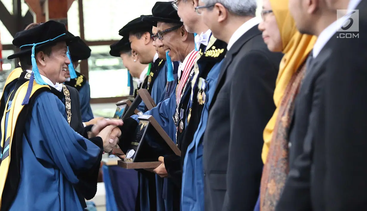Rektor Institut Teknologi Bandung (ITB) Kadarsah Suryadi bersalaman usai memberi plakat dalam acara Dies Natalis ke-59 ITB di Aula Barat ITB, Bandung, Jawa Barat, Jumat (2/3). (Liputan6.com/Immanuel Antonius)
