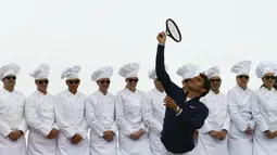 Petenis Swiss, Roger Federer, melakukan servis saat bermain tenis di ketinggian 3.475 meter melawan pemain ski AS, Lindsey Vonn, di gletser Aletsch, Jungfraujoch, (17/7/2014). (REUTERS/Denis Balibouse)